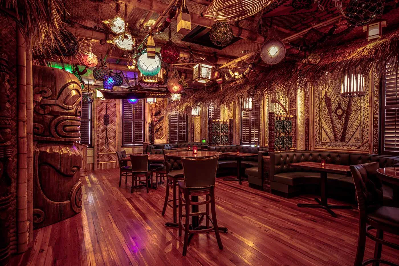 Inside the Bamboo Room tiki bar, with bamboo walls, hanging lanterns, and warm string lights
